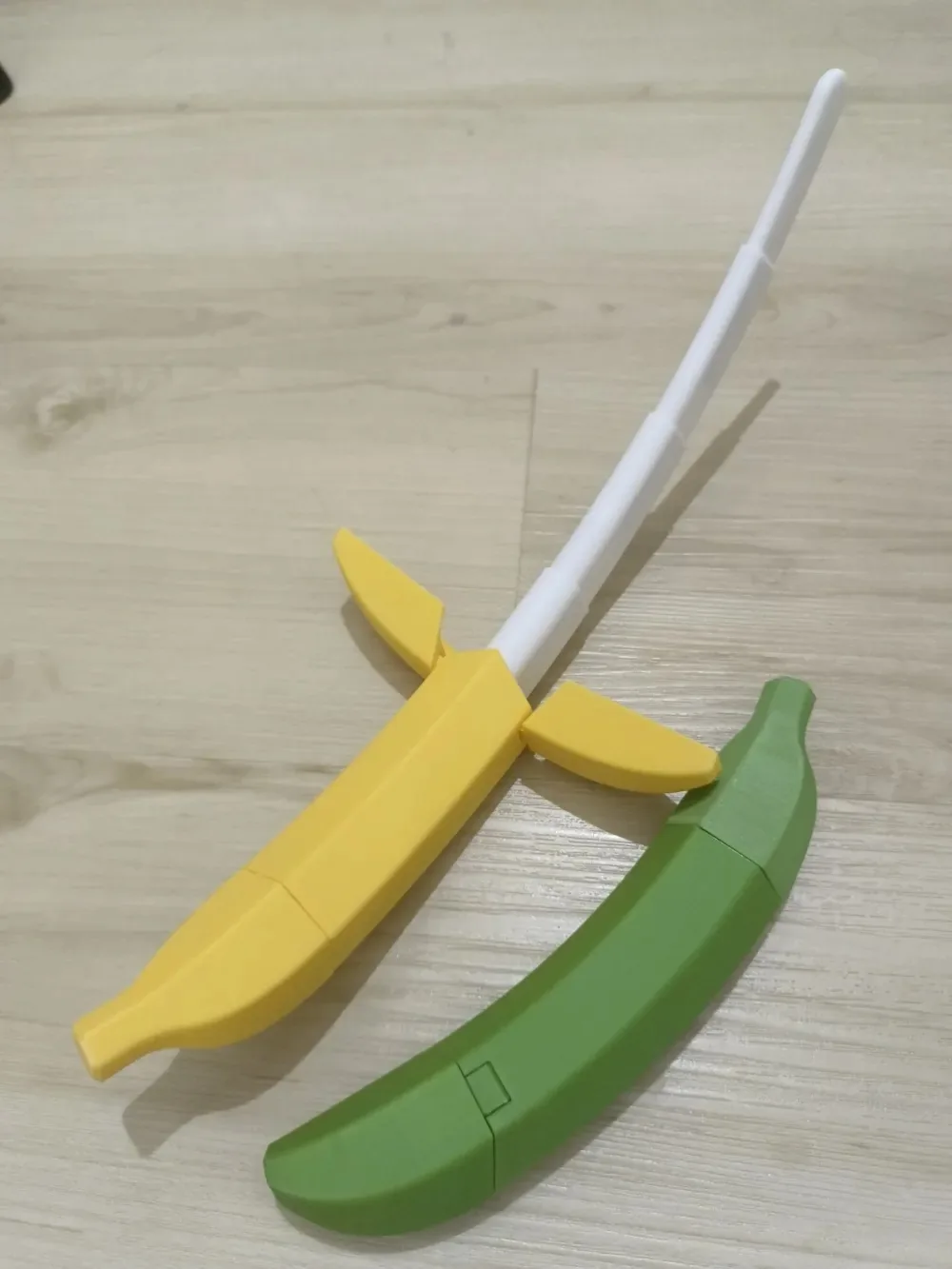 Cuchillo con mango en forma de plátano amarillo junto a su estuche verde