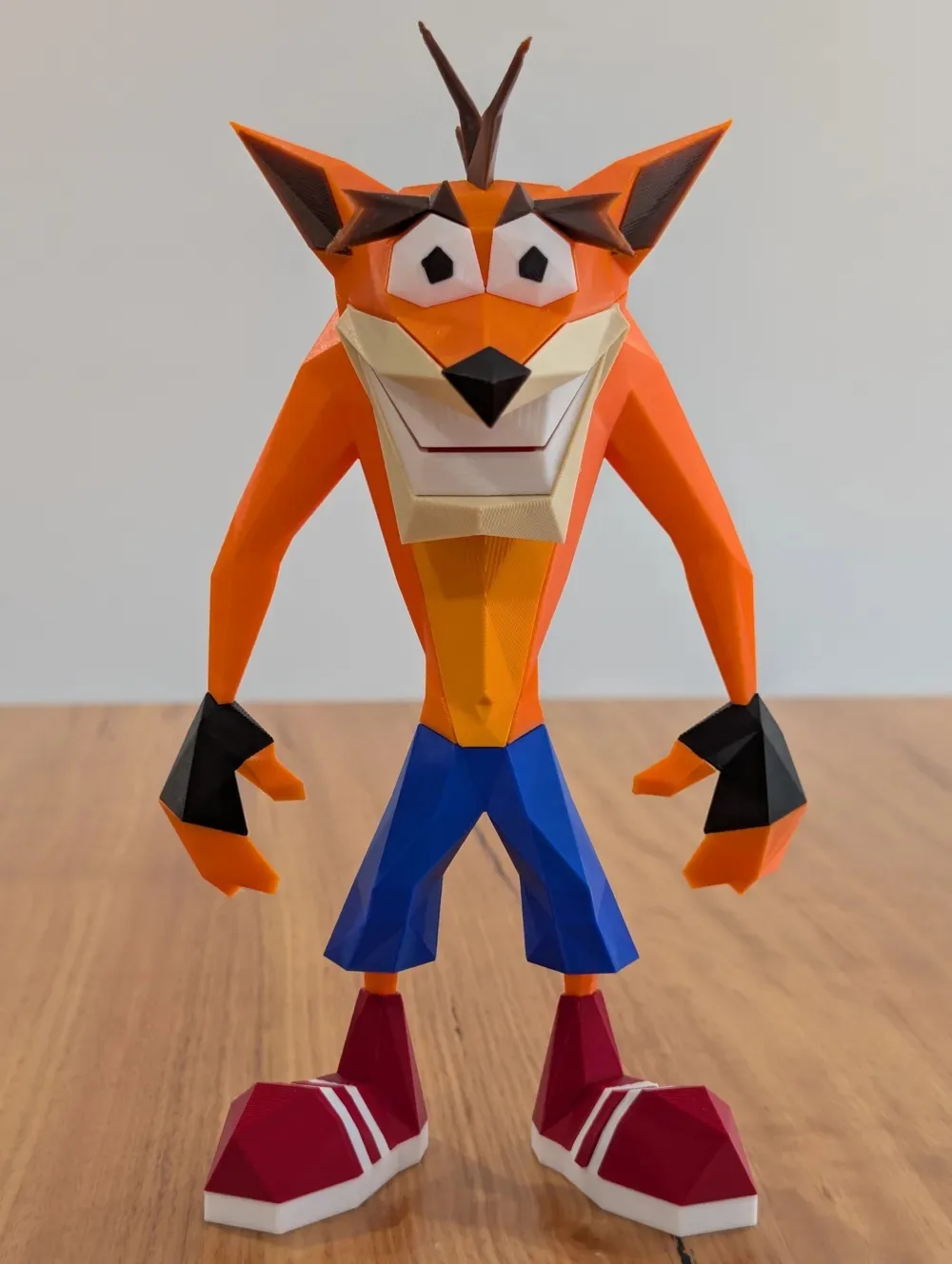 Figura de Crash Bandicoot impresa en 3D, en estilo geométrico naranjo y azul