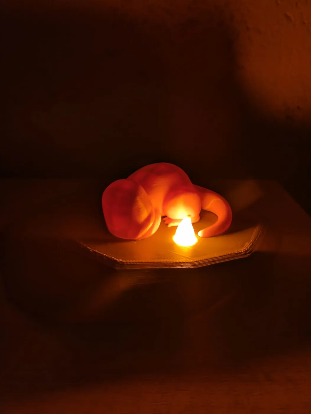 Lámpara con un zorro dormido, encendida en la oscuridad con luz naranja