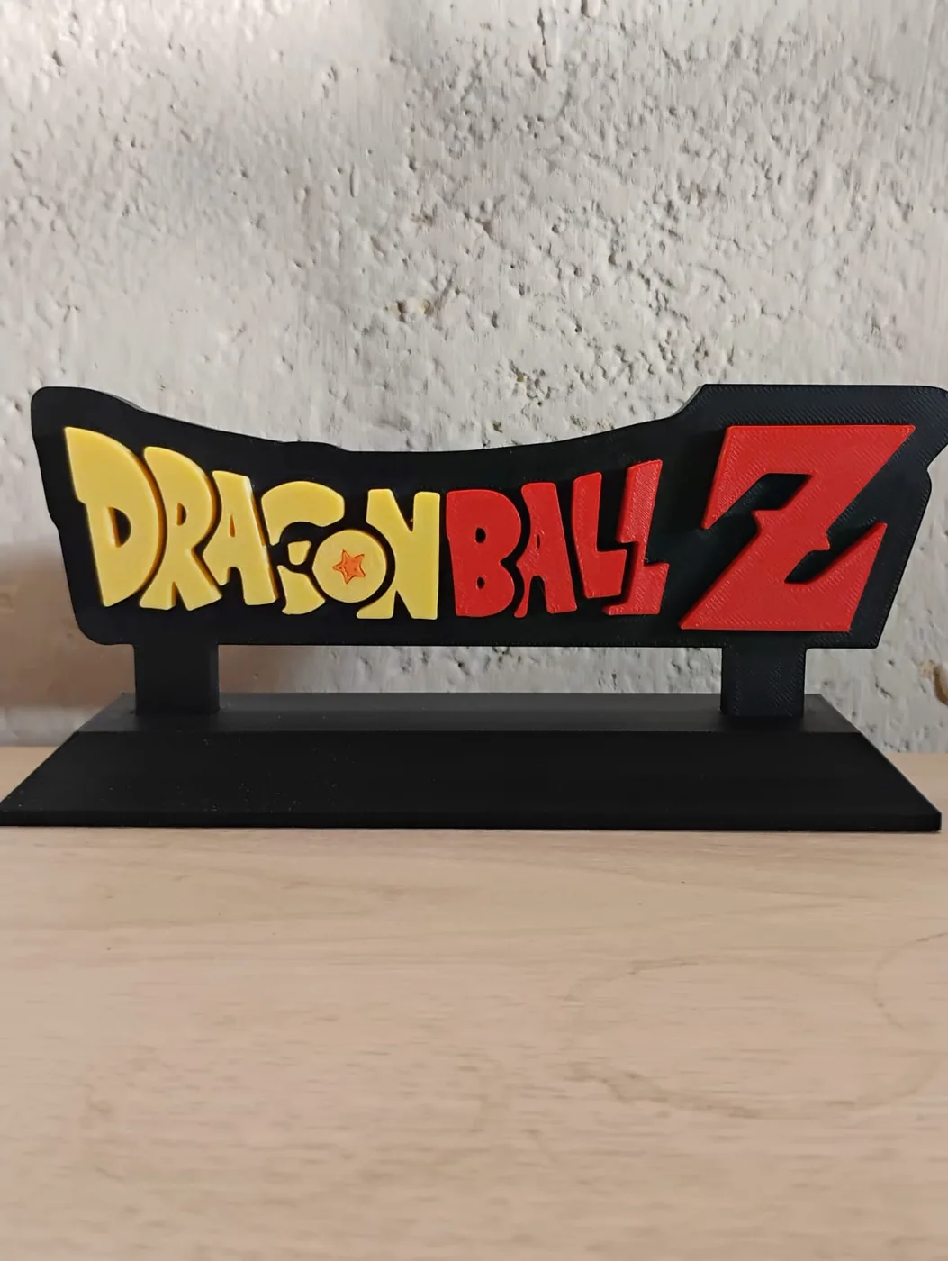Letrero con el logo de Dragon Ball Z en amarillo y rojo sobre base negra