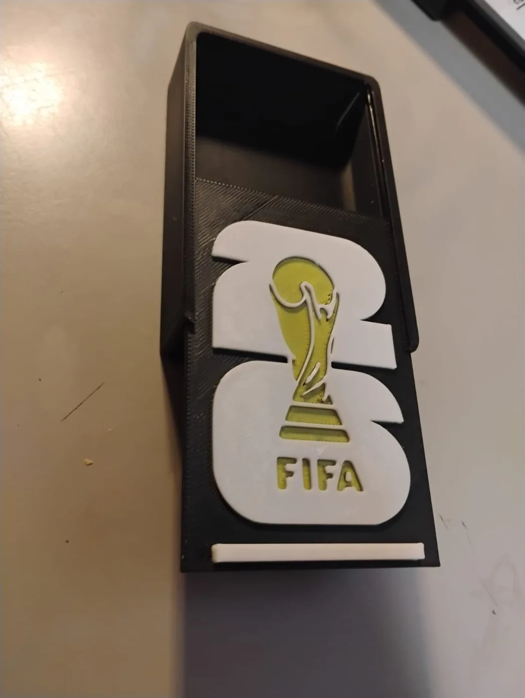 Portacelular negro con el emblema de FIFA 26 en blanco y dorado