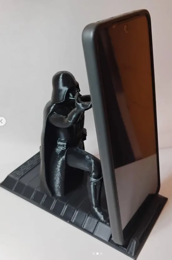 Portacelular con la figura de Darth Vader arrodillado sosteniendo un teléfono